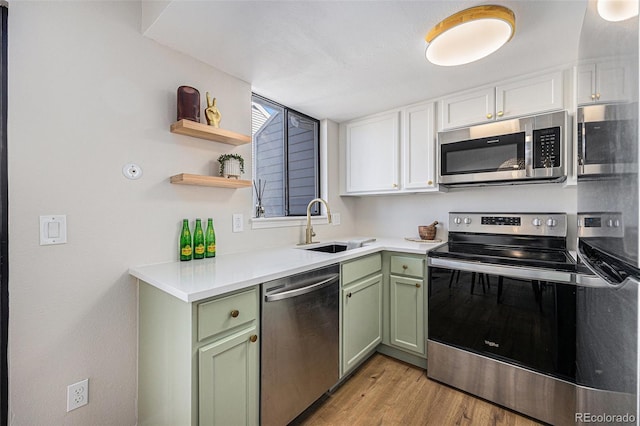 kitchen featuring sink, appliances with stainless steel finishes, white cabinets, green cabinetry, and light wood-type flooring