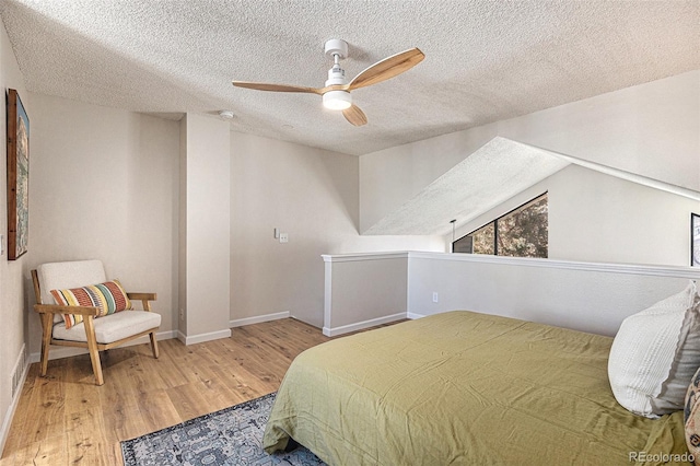 bedroom with hardwood / wood-style flooring, lofted ceiling, a textured ceiling, and ceiling fan