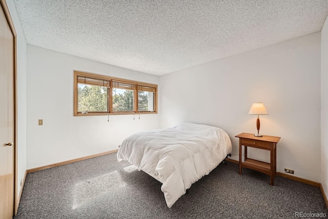 bedroom with baseboards, a textured ceiling, and carpet