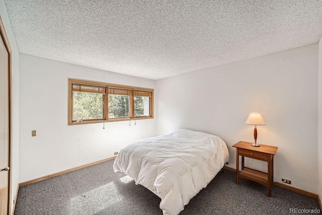 carpeted bedroom with a textured ceiling and baseboards