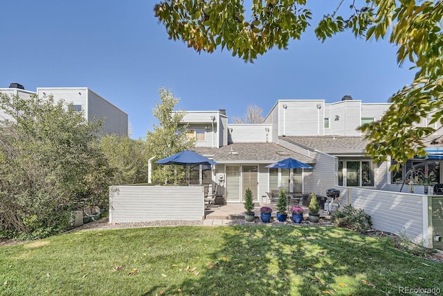 rear view of house with a lawn and a patio area