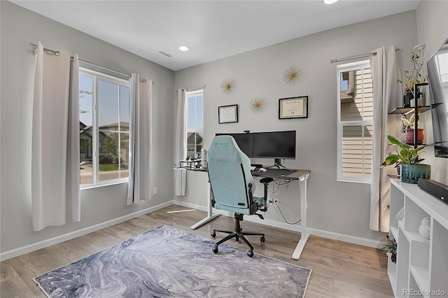 office space with light hardwood / wood-style floors and plenty of natural light