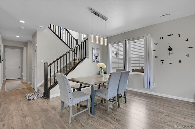 dining space with an inviting chandelier and light hardwood / wood-style floors