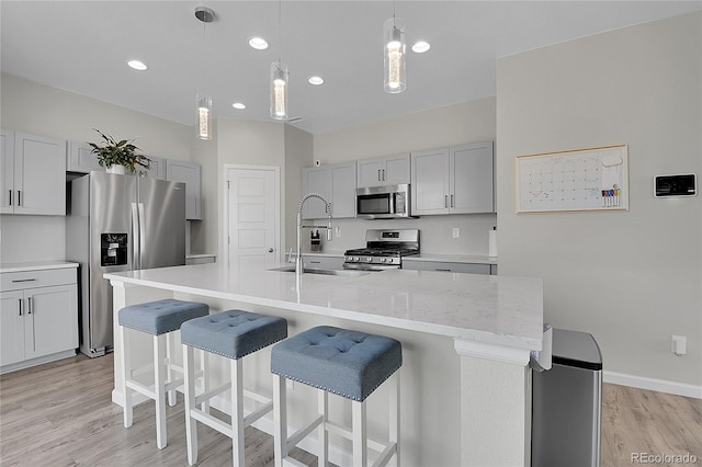 kitchen featuring sink, a center island with sink, pendant lighting, and stainless steel appliances