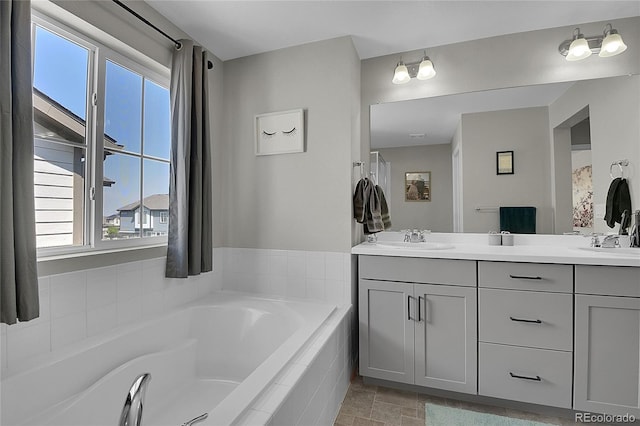 bathroom with tiled bath and vanity