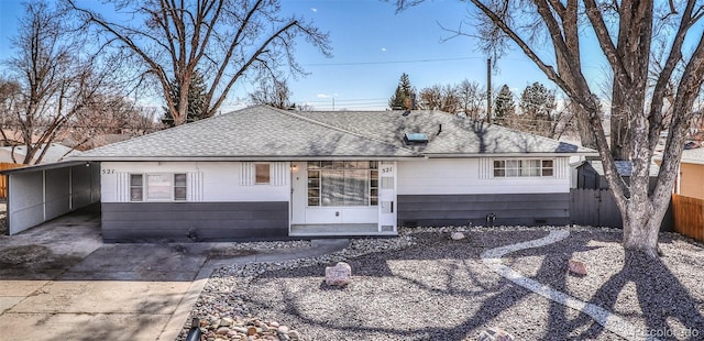 view of front facade with crawl space, fence, a carport, and a shingled roof