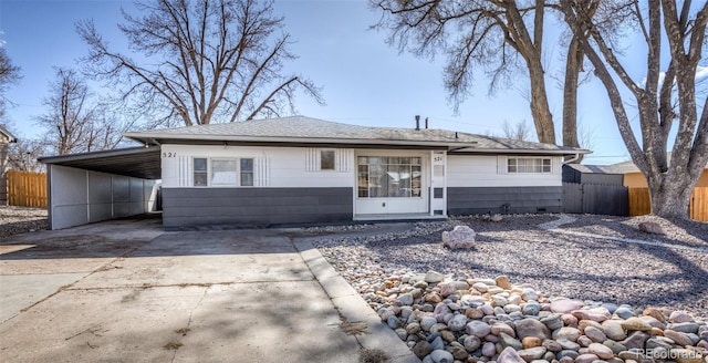 view of front facade featuring a carport, crawl space, concrete driveway, and fence