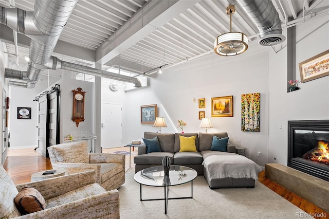 living area featuring a glass covered fireplace and a high ceiling