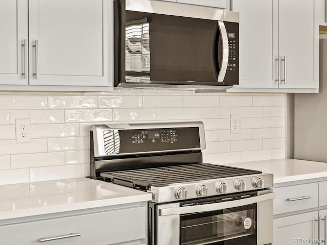 kitchen featuring tasteful backsplash, appliances with stainless steel finishes, and white cabinets