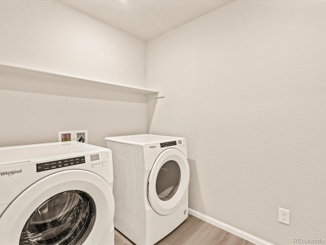 washroom with separate washer and dryer and light hardwood / wood-style floors