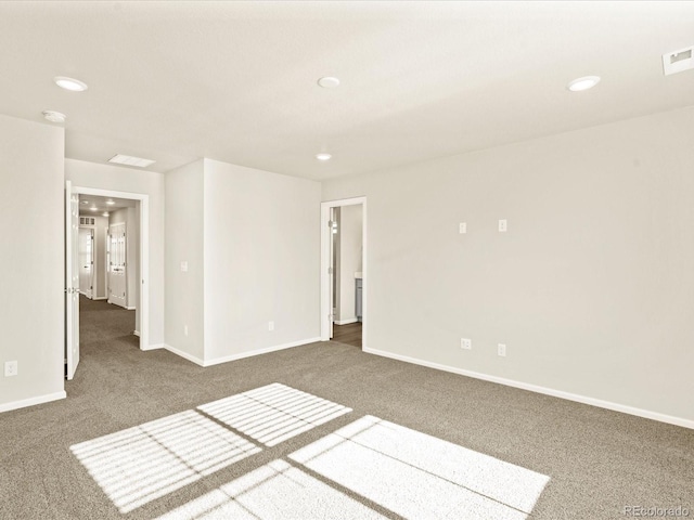 unfurnished room with dark colored carpet