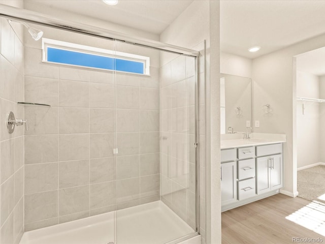 bathroom featuring walk in shower, vanity, and hardwood / wood-style floors