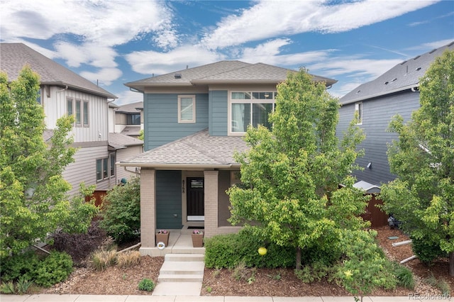 8768 E 54th Pl, Denver, CO 80238 - view of front of house with roof with shingles, covered porch, and brick siding