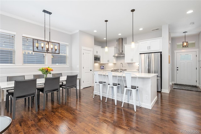 8768 E 54th Pl, Denver, CO 80238 - kitchen with wall chimney exhaust hood, stainless steel appliances, light countertops, dark wood-type flooring, and tasteful backsplash