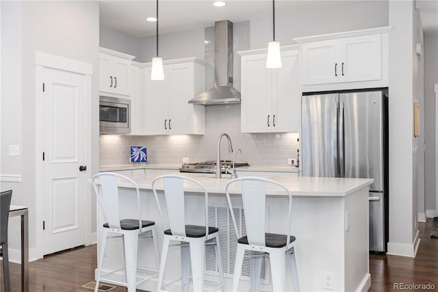 8768 E 54th Pl, Denver, CO 80238 - kitchen featuring appliances with stainless steel finishes, wall chimney exhaust hood, a kitchen island with sink, light countertops, and backsplash
