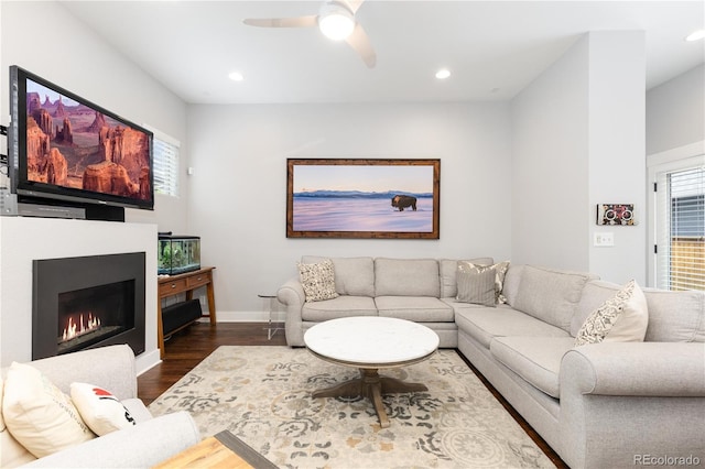 8768 E 54th Pl, Denver, CO 80238 - living room with dark wood-type flooring, a ceiling fan, baseboards, recessed lighting, and a warm lit fireplace