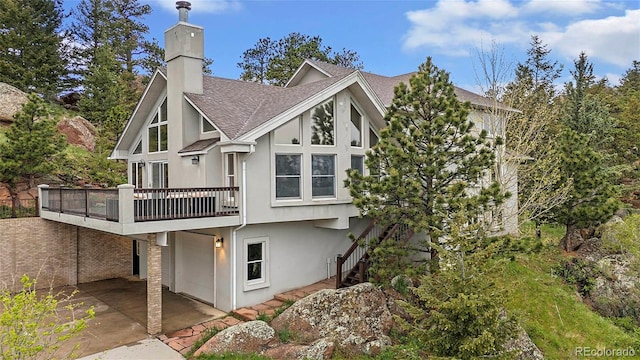 9001 Eastridge Rd, Golden, CO 80403 - rear view of property with a shingled roof, a patio, a chimney, and stucco siding