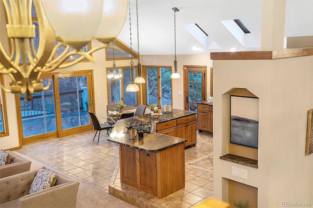9001 Eastridge Rd, Golden, CO 80403 - kitchen featuring a skylight, vaulted ceiling, brown cabinetry, a large island, and light tile patterned floors