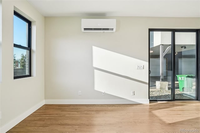 1559 N Hooker St, Denver, CO 80204 - unfurnished room featuring a wall mounted AC and wood finished floors
