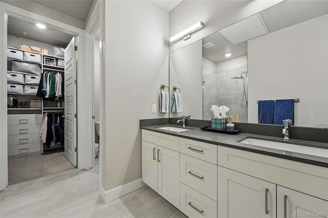 20 Wilcox St Unit 208, Castle Rock, CO 80104 - bathroom with a stall shower, double vanity, a spacious closet, and tile patterned floors