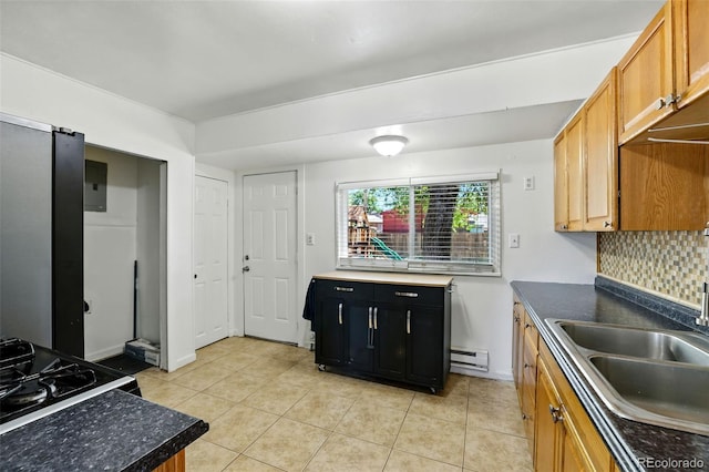 613 S Union Blvd, Colorado Springs, CO 80910 - kitchen featuring a baseboard radiator, light tile patterned floors, decorative backsplash, dark countertops, and brown cabinetry