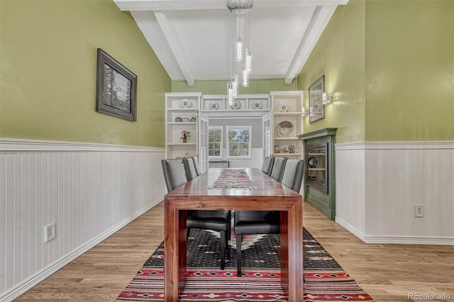 dining room with beam ceiling and light wood-type flooring