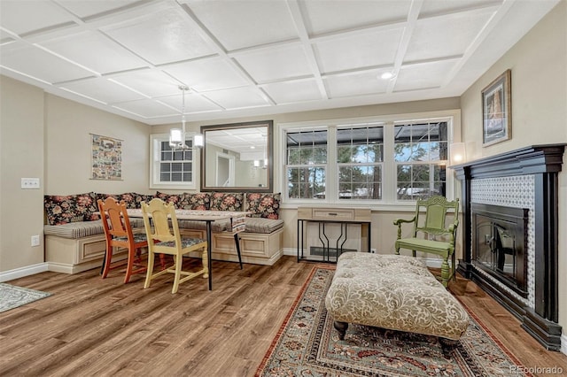 living room with a fireplace, coffered ceiling, and hardwood / wood-style flooring