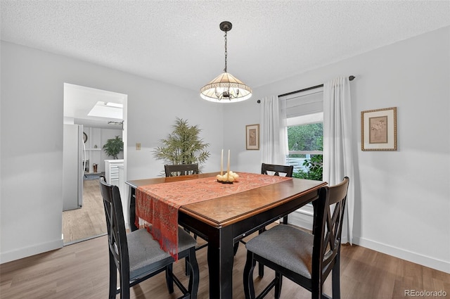 3070 W Enchanted Cir, Colorado Springs, CO 80917 - dining space with light wood-type flooring, baseboards, and a textured ceiling