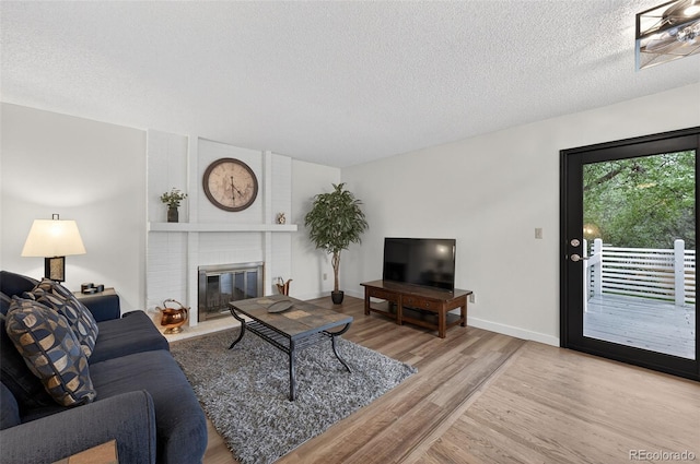 3070 W Enchanted Cir, Colorado Springs, CO 80917 - living area with a textured ceiling, wood finished floors, and a brick fireplace