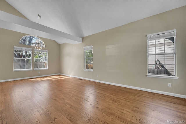 9008 W 101st Ave, Broomfield, CO 80021 - unfurnished room featuring vaulted ceiling, a chandelier, healthy amount of natural light, and wood finished floors
