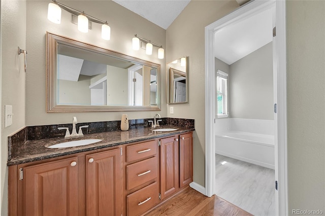 9008 W 101st Ave, Broomfield, CO 80021 - bathroom featuring double vanity, wood finished floors, and a garden tub