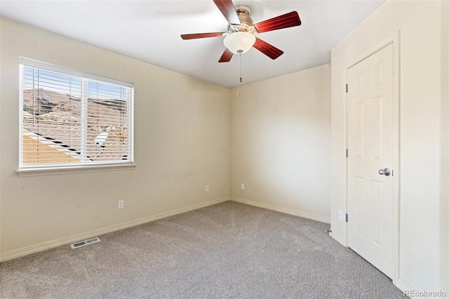 carpeted spare room featuring ceiling fan