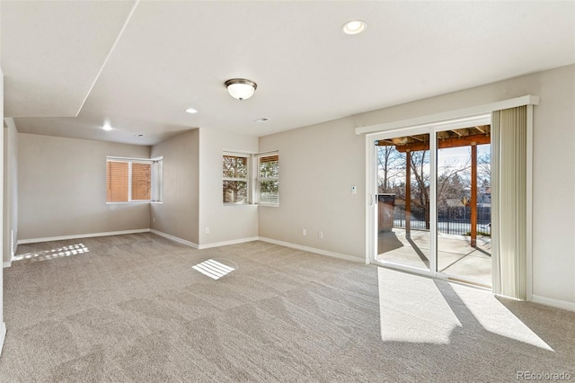 empty room with light colored carpet and a healthy amount of sunlight