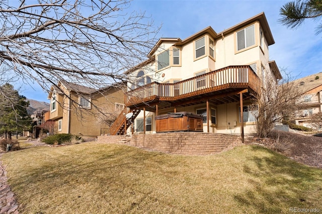 rear view of property with a lawn, a hot tub, and a deck