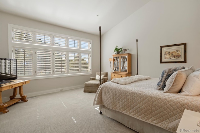 bedroom featuring lofted ceiling, multiple windows, and carpet floors