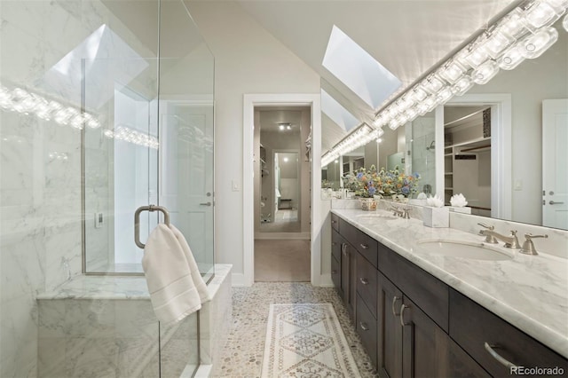 bathroom featuring vanity, a skylight, and a shower with shower door