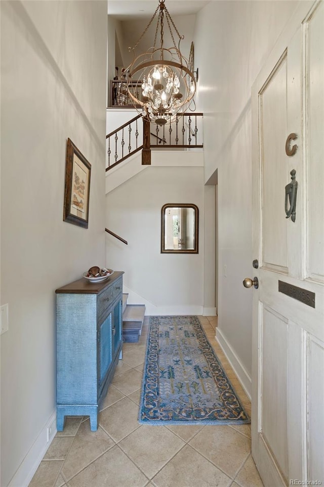 tiled foyer featuring a notable chandelier and a high ceiling