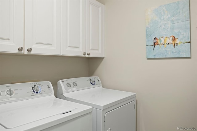 washroom with washing machine and dryer and cabinets