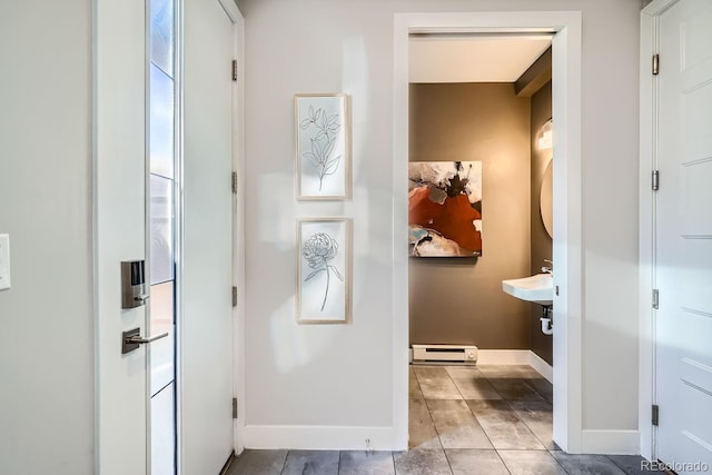 bathroom featuring a baseboard heating unit, tile patterned flooring, and baseboards