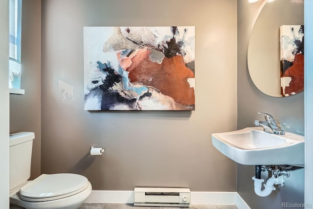 bathroom with toilet, a baseboard radiator, baseboards, and a sink