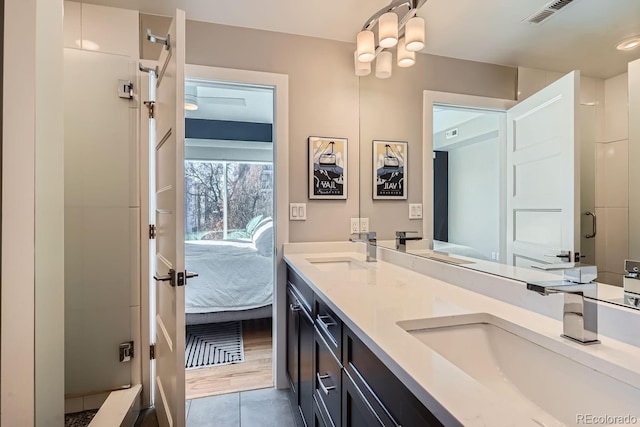 bathroom with ensuite bathroom, double vanity, a sink, and visible vents