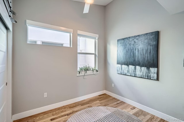 unfurnished room with light wood-style floors, a healthy amount of sunlight, and baseboards