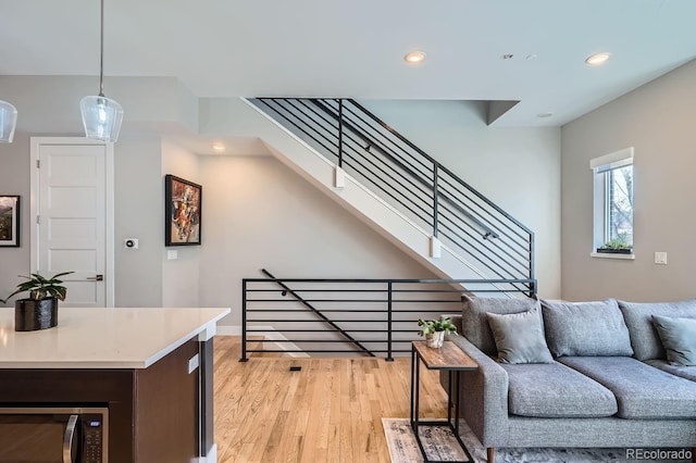 living area featuring light wood-style flooring, stairway, and recessed lighting