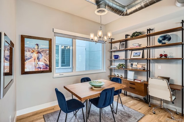 dining space with baseboards, an inviting chandelier, visible vents, and light wood-style floors