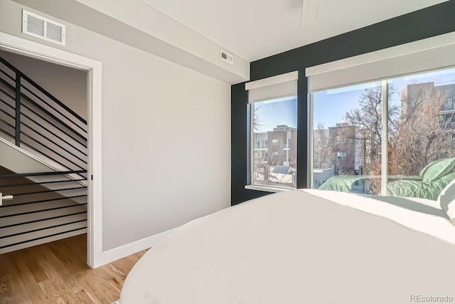 bedroom featuring visible vents, light wood-style flooring, and baseboards