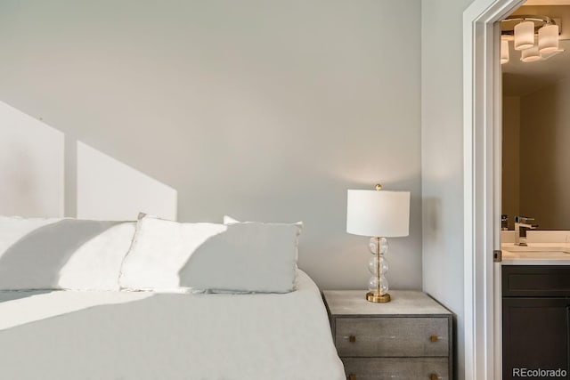 bedroom featuring a sink and ensuite bathroom