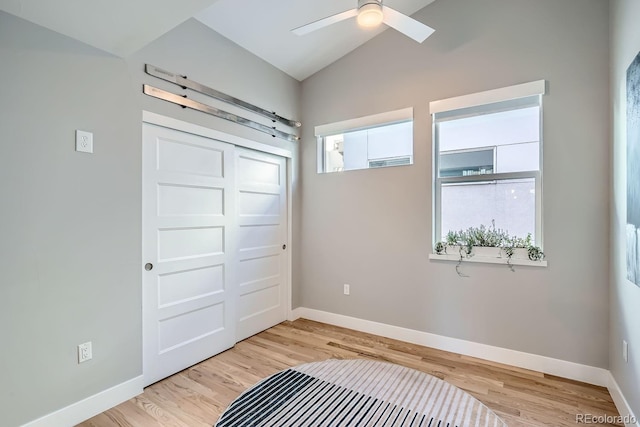 interior space with lofted ceiling, a closet, light wood-style flooring, and baseboards