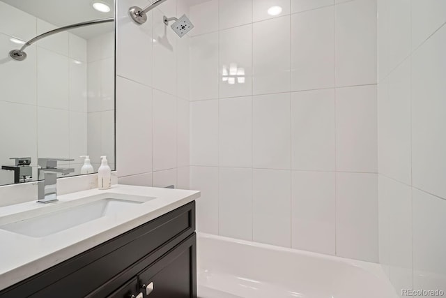 bathroom with washtub / shower combination, tile walls, and vanity