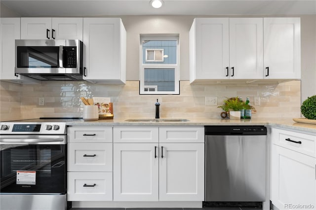 kitchen featuring white cabinets, appliances with stainless steel finishes, and backsplash