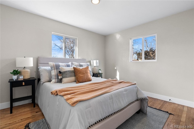 bedroom with wood-type flooring and multiple windows